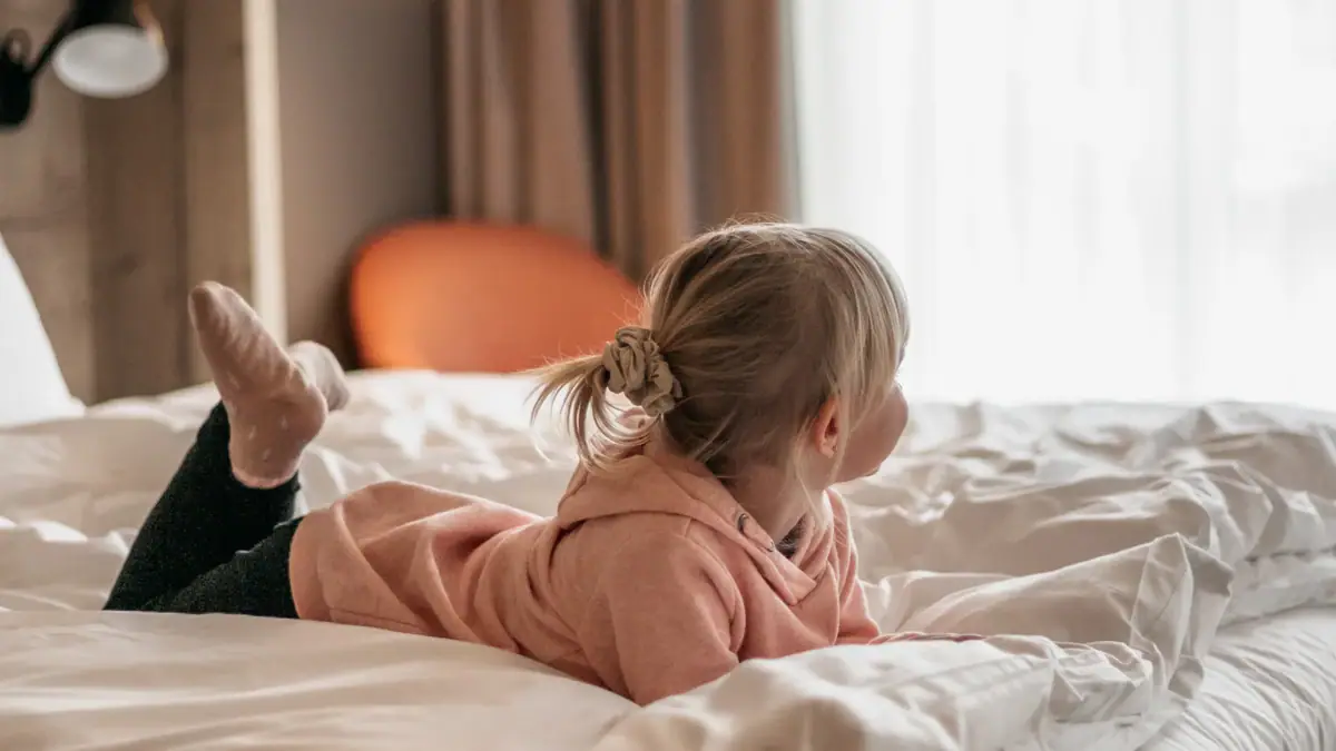 Zimmer aja Garmisch-Partenkirchen Ein Kind liegt auf einem Bett.