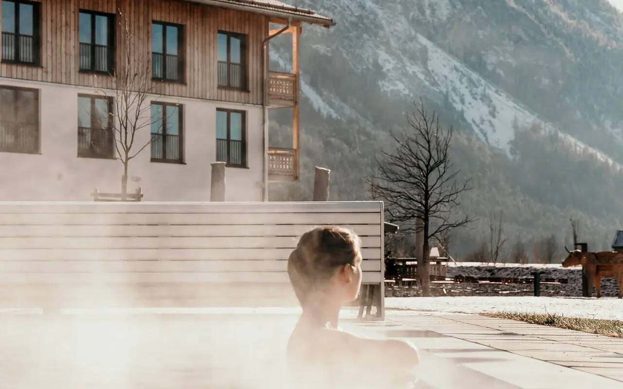 Außenpool aja Ruhpolding Eine Frau entspannt im warm dampfenden Außenpool vom aja Ruhpolding.