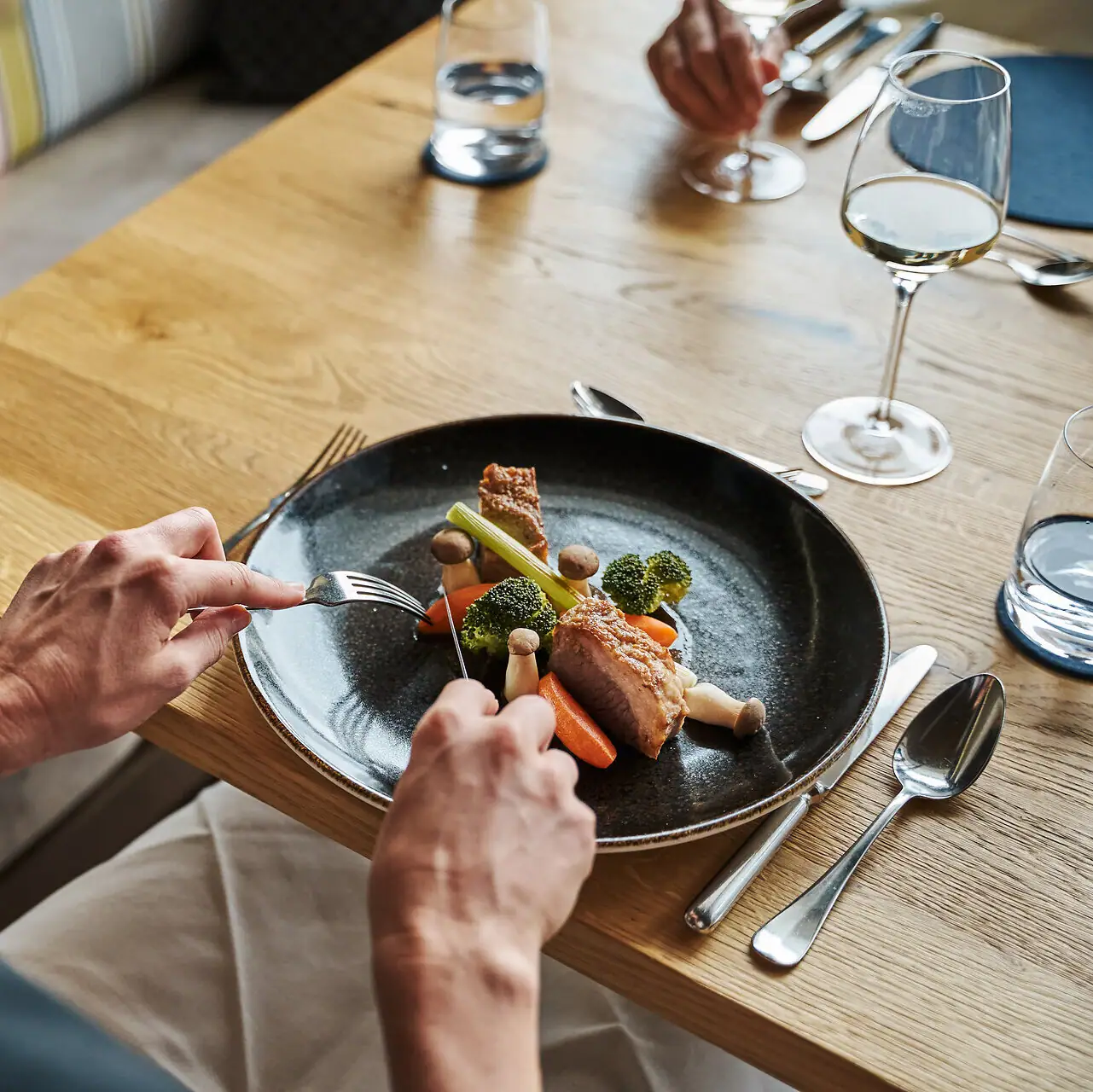 Teller mit Fleisch Eine Person isst Essen von einem Teller.