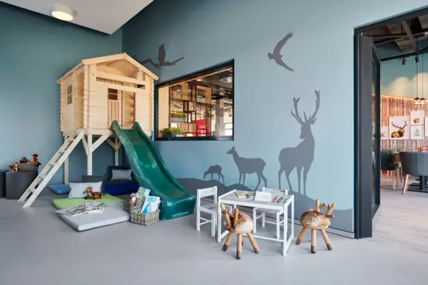 Spielzimmer Ein Raum mit einer Rutsche und einem Wandgemälde.