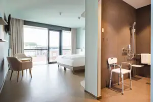 Behindertenfreundliches Zimmer Ein Zimmer mit einem Bett und Stühlen.