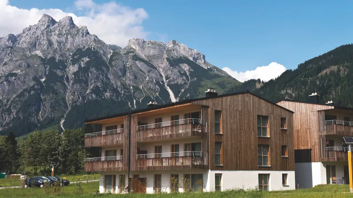 Ferienwohnungen Werfenweng Ein Gebäude mit einem Berg im Hintergrund.