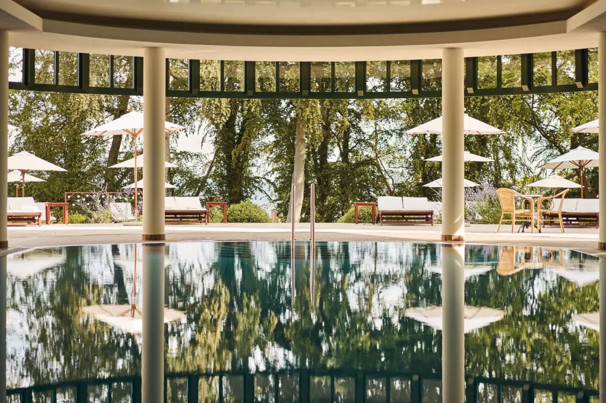 Panorama Innenpool Pool mit Sonnenschirmen und Stühlen im Hintergrund