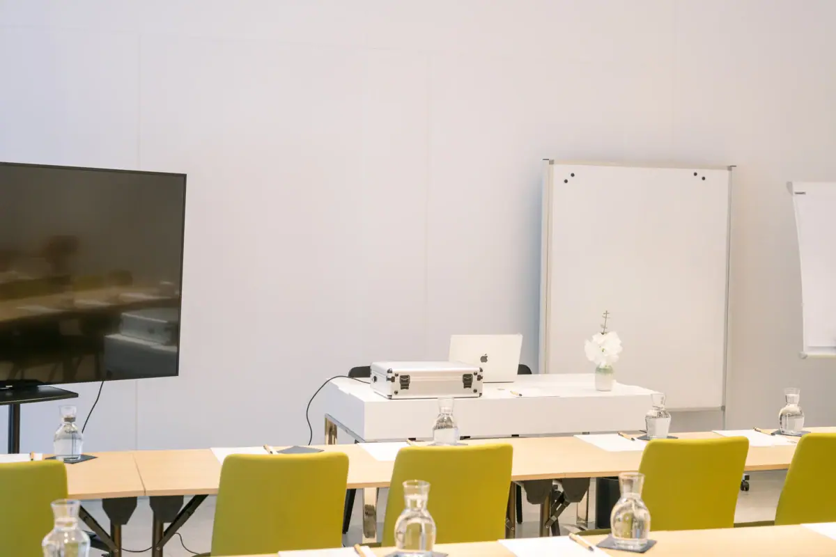 Tagungsraumdetails Ein Raum mit Tischen und Stühlen.