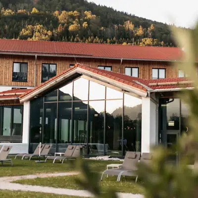 Inklusivleistungen in deinem aja Hotel Ein Gebäude mit Glaswand und Stühlen davor.