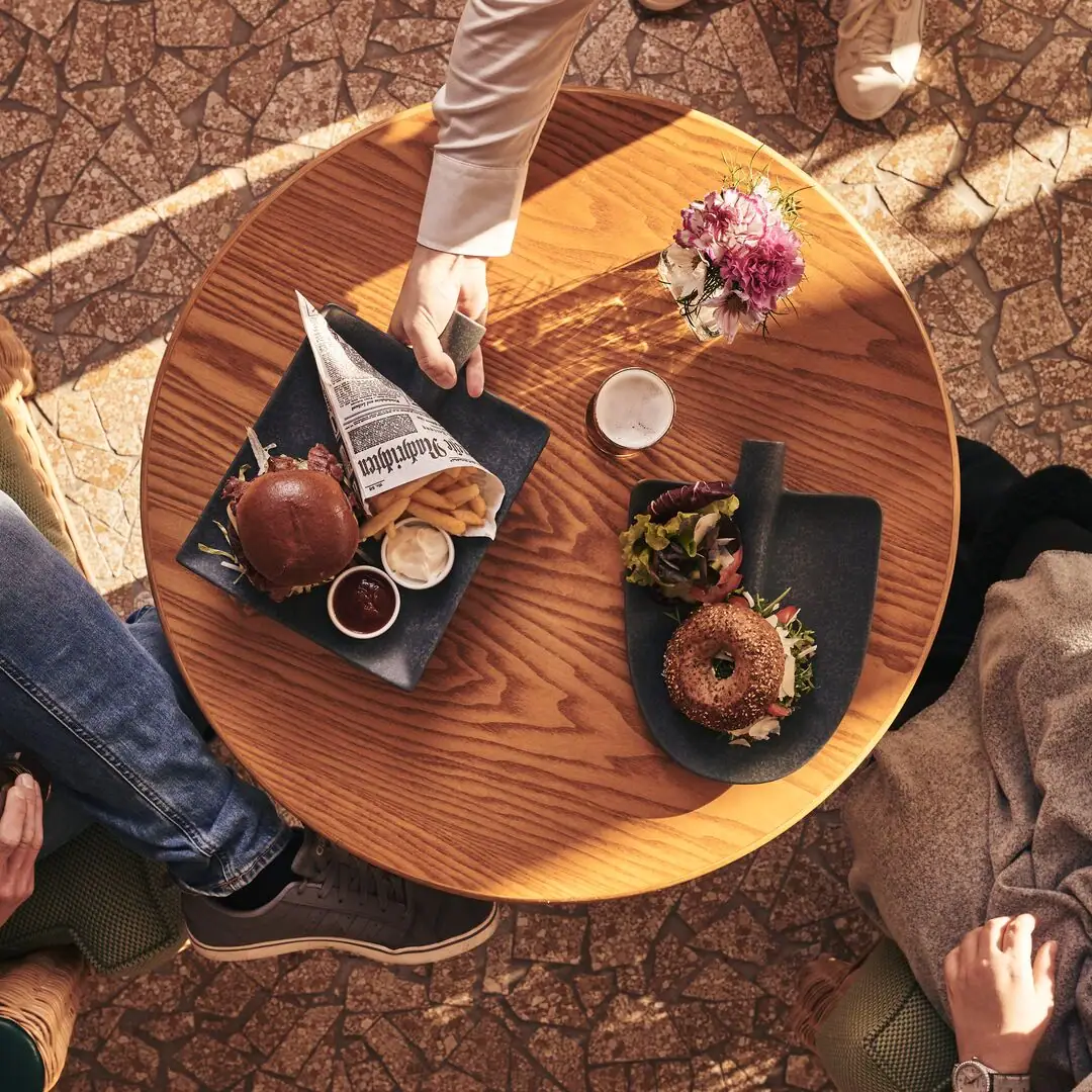 Tisch mit Gerichten Person hält einen Teller mit Essen auf einem Tisch.