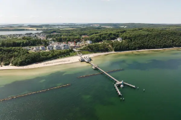 Seebrücke Sellin Ein Steg an einem Strand mit Blick auf das Wasser und den Himmel.