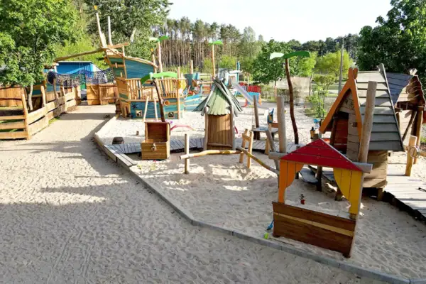 Scharmuntzelland Ein Spielplatz mit bunten Spielgeräten.
