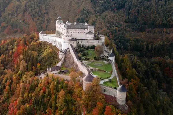 Festung Burg auf einem Hügel mit Bäumen im Herbst.