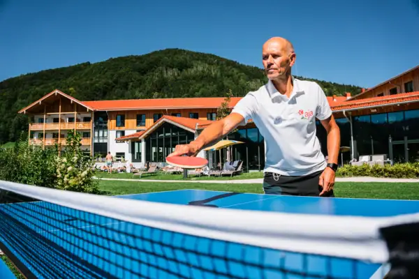 Tischtennis Ein Mann hält einen Tennisschläger.