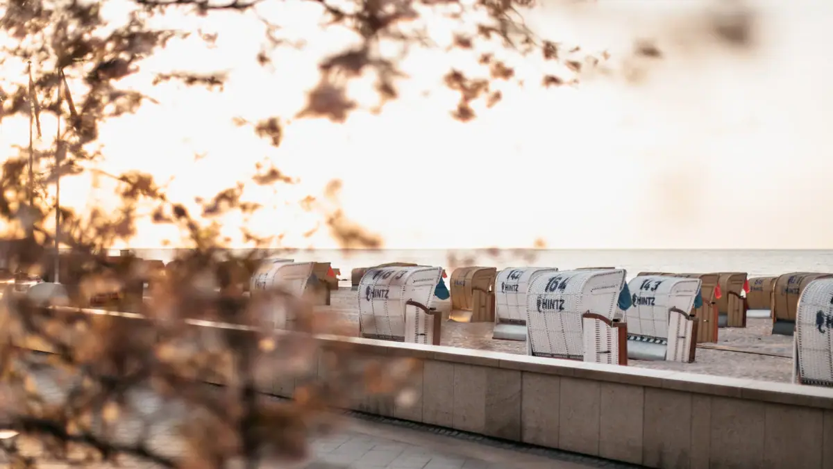 Grömitz Strand Eine Reihe weißer Strandkörbe mit blauer Schrift.