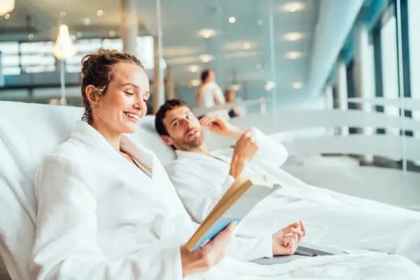 Ein Mann und eine Frau in Bademänteln lesen ein Buch.