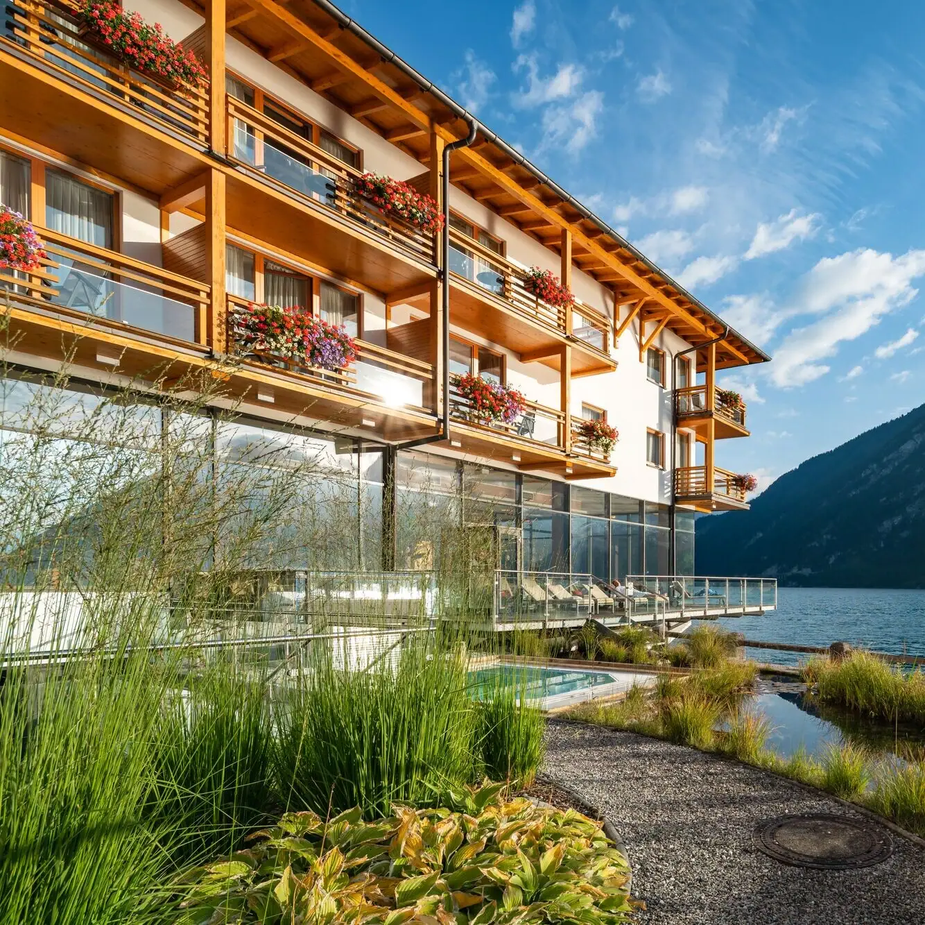 Fürstenhaus am Achensee Ein Gebäude mit einem See und Bergen im Hintergrund.