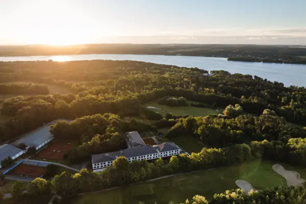 Scharmützelsee Ein großes Gewässer mit einem Gebäude und Bäumen.