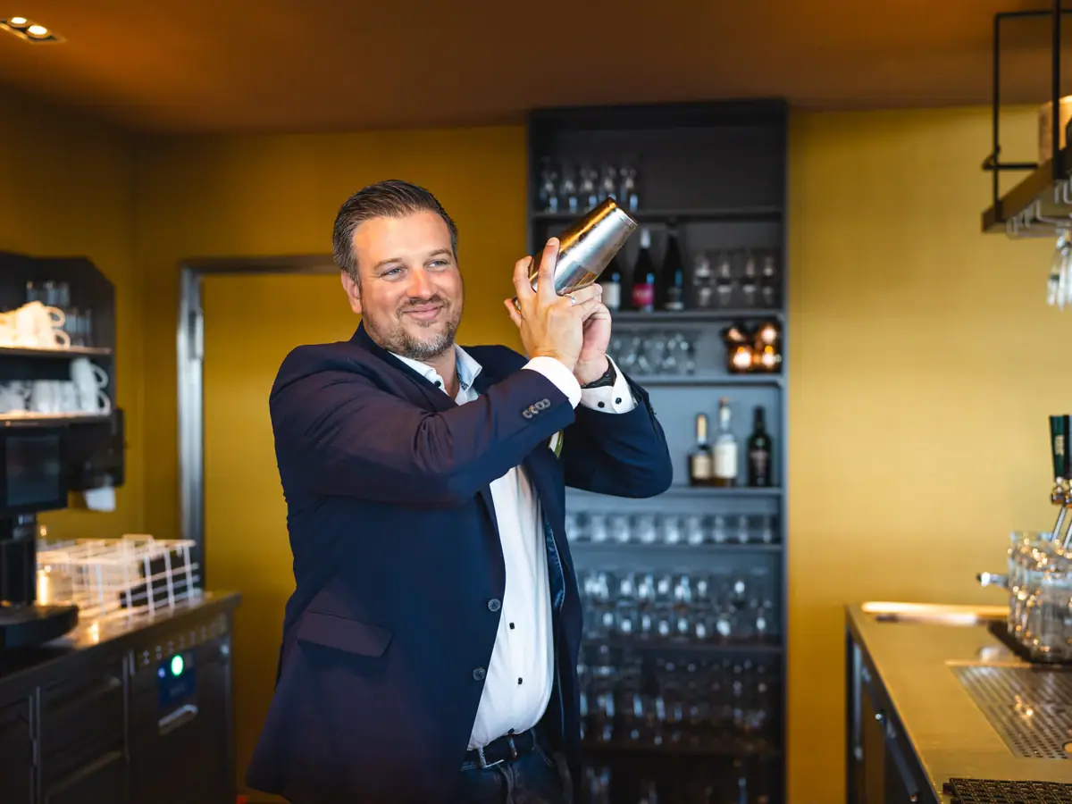 Barkeeper Ein Mann hält einen Shaker.