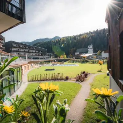 Bergresort Werfenweng Grasfläche mit Gebäuden und Bäumen im Hintergrund