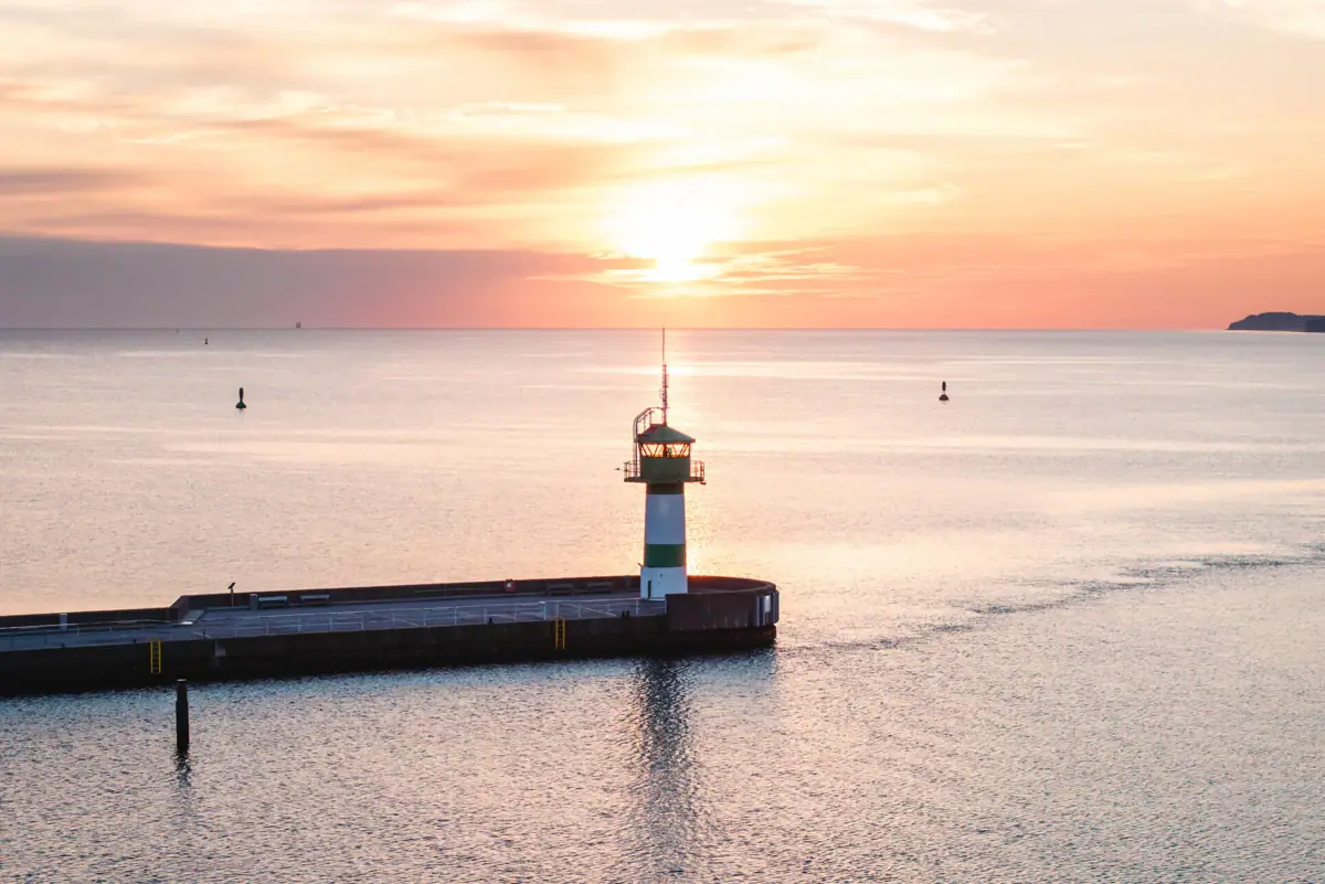 Ein Pier mit einem Leuchtturm im Wasser.