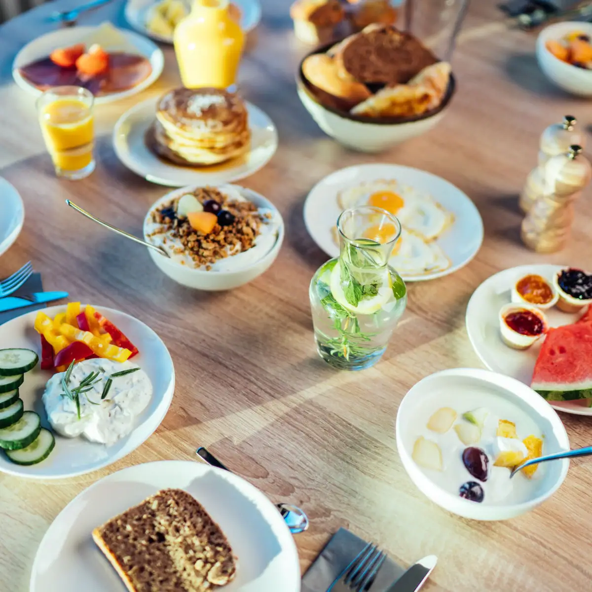 Frühstückstisch Ein Tisch mit Tellern voller Speisen und Getränken.