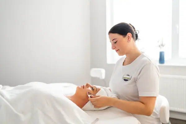 SPA-Anwendung Eine Frau erhält eine Gesichtsmassage.