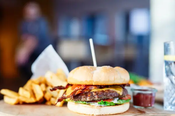 Burger mit Pommes Burger und Pommes auf einem Holzbrett.