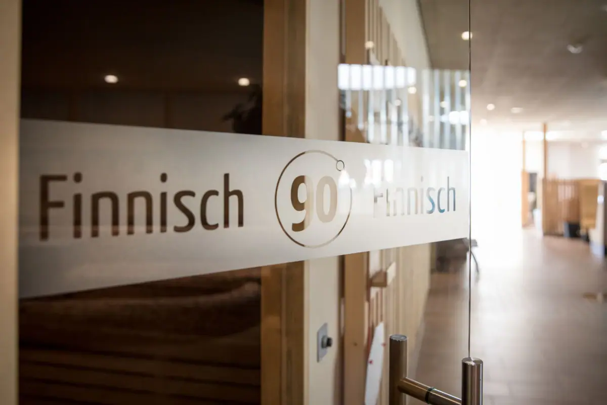 Ein Schild an einer Glastür auf der steht Finnische Sauna