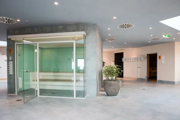 Dampfbad im aja Warnemünde Glastür zum Dampfbad mit moderner Inneneinrichtung und Zimmerpflanze.