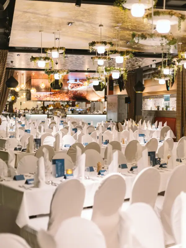 Silvesterparty im aja Bad Saarow Ein Raum mit Tischen und Stühlen, eingerichtet für eine Feier.