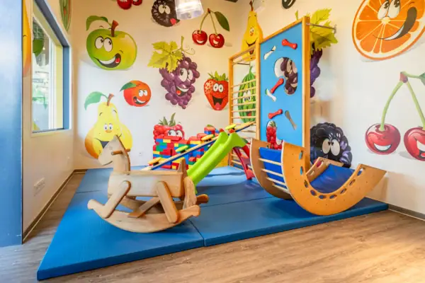 Kinderecke aja Bad Saarow Spielbereich in einem Raum mit Kinderkunst an der Wand.