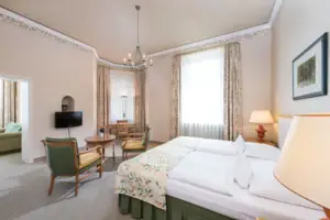 Suite Ein Zimmer mit einem Bett und Stühlen.