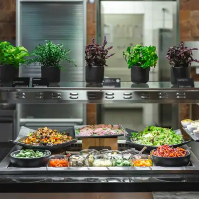 Restaurant im aja Bad Saarow Lebensmittel auf einem Regal in einer Küche.