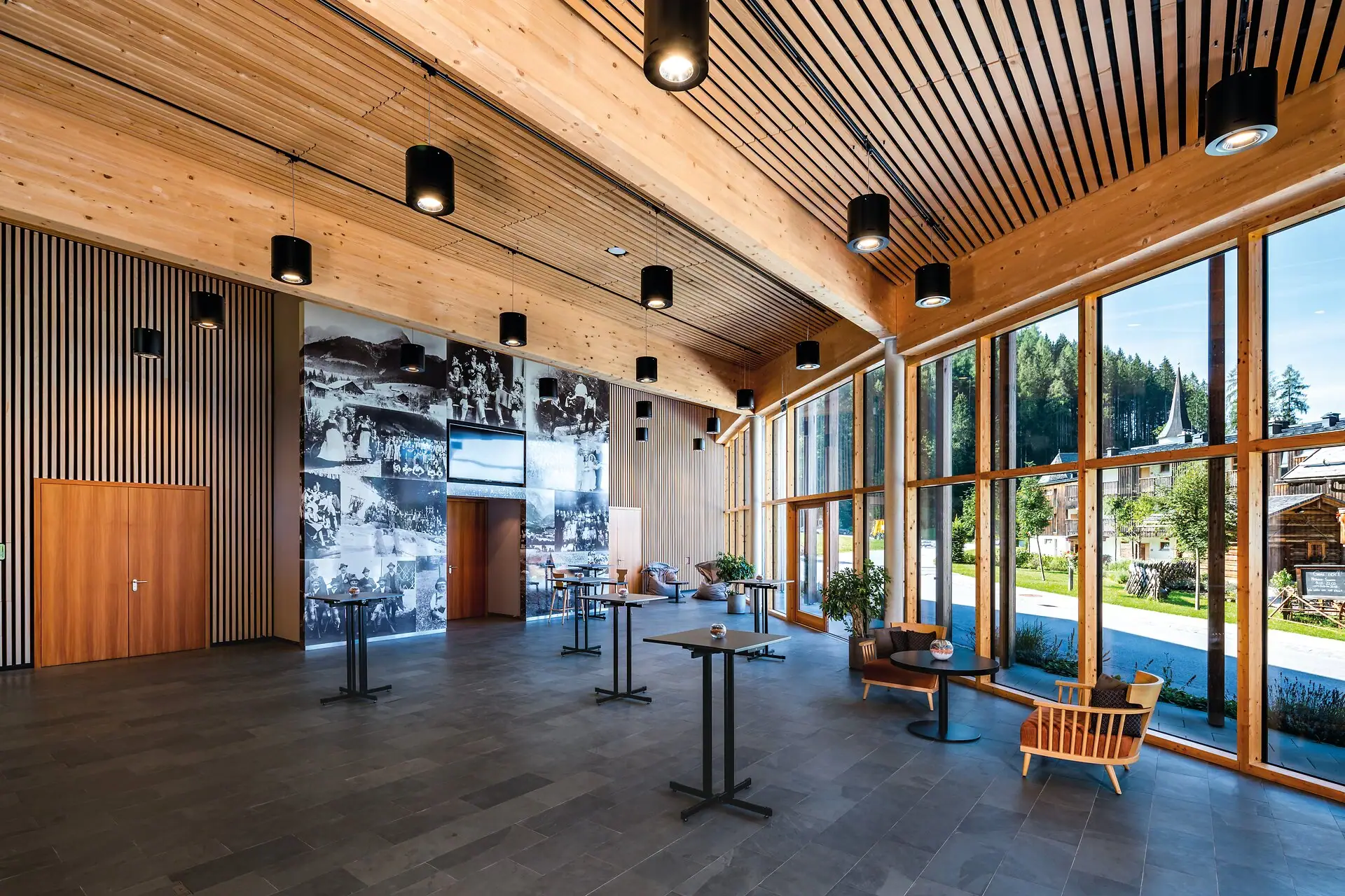 Foyer Tagungsraum Ein Raum mit großen Fenstern und einer großen Wand.