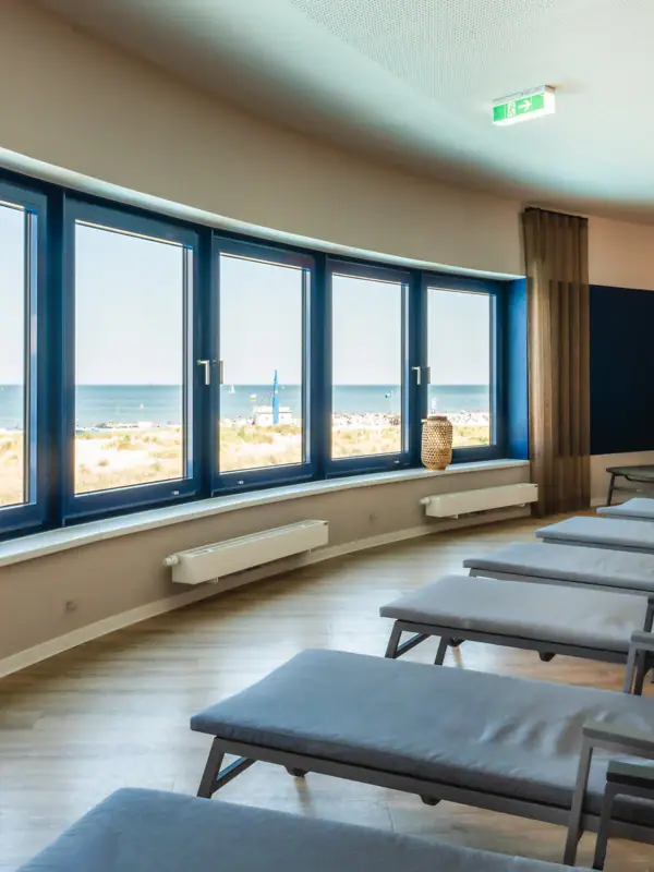 Ruheraum Ein Raum mit Stühlen und großen Fenstern.