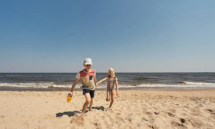 Kinder am Strand Ein Junge und ein Mädchen laufen am Strand.