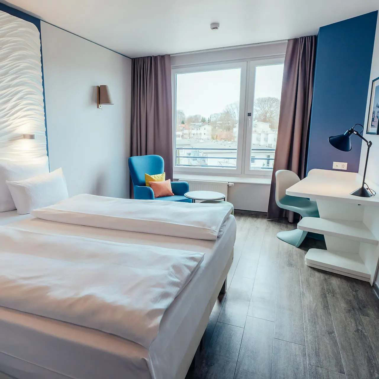 Doppelzimmer Ein Zimmer mit zwei Betten und einem Tisch.