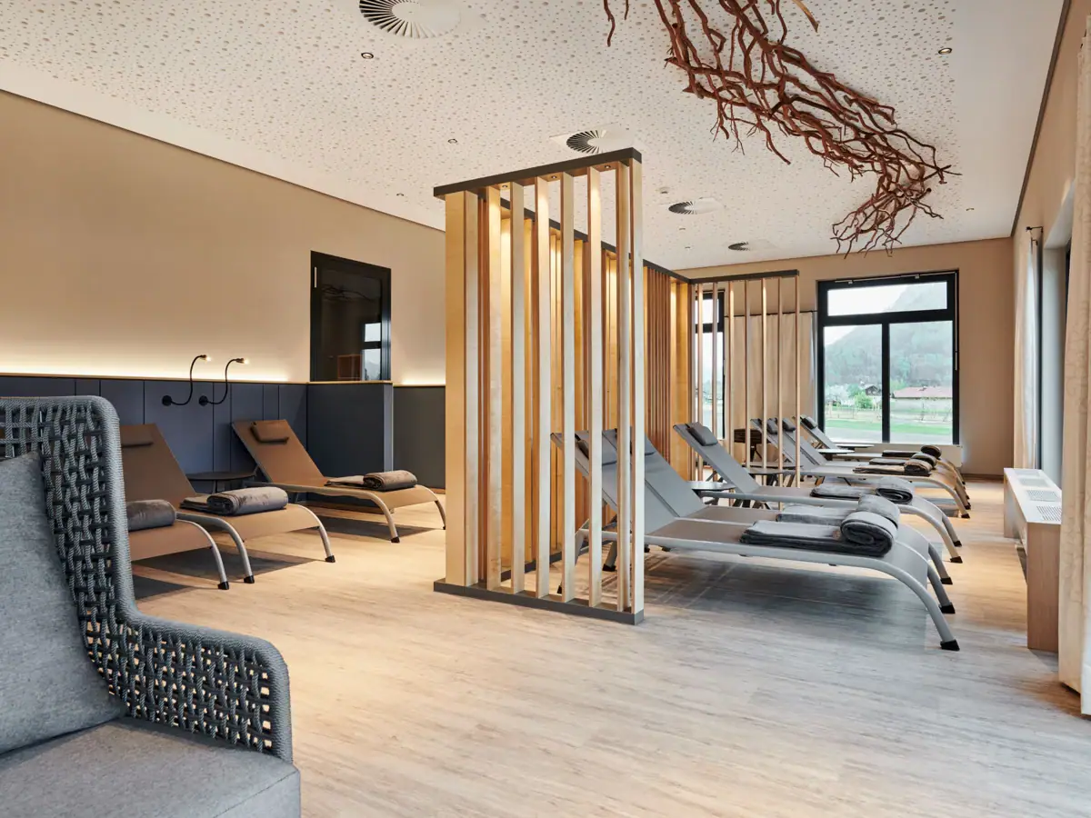 Ruhebereich in der Saunalandschaft Ein Raum mit Lounge-Sesseln und einer Holzstruktur.