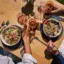 Essen und Trinken am Achensee Gruppe von Personen beim Essen an einem Tisch mit verschiedenen Speisen und Getränken.