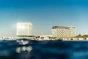 aja Warnemünde Ein Gewässer mit dem aja Warnemünde im Hintergrund.