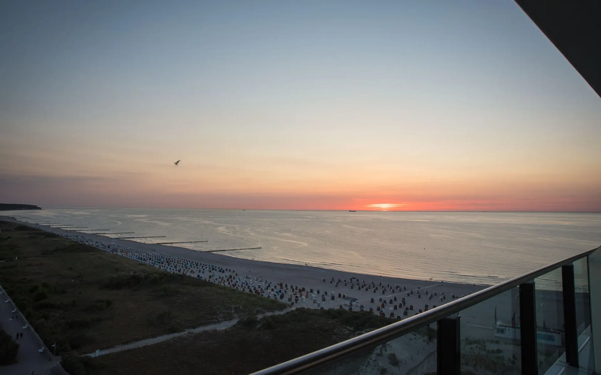 Blick vom Balkon auf einen Sonnenuntergang über dem Meer