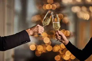 Anstoßen mit Sekt Zwei Hände halten Weingläser.