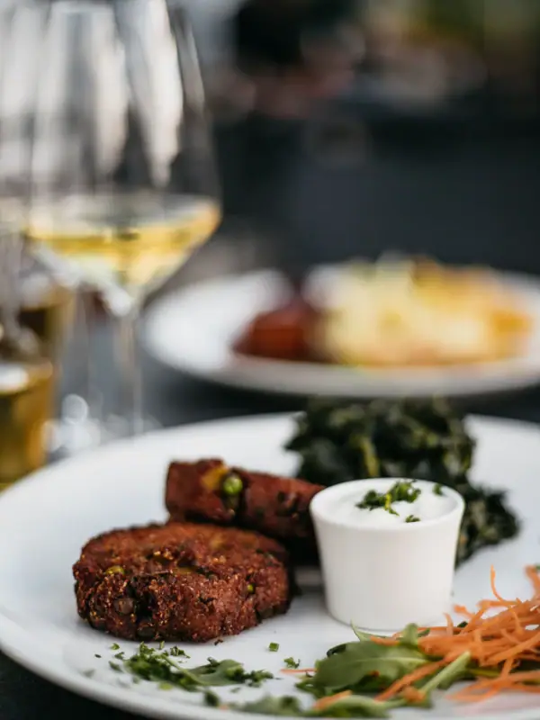 Hauptgericht auf einem Teller Ein Teller mit Essen und ein Glas Wein.