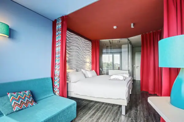 Ein Zimmer mit einem Bett und einem blauen Sofa.