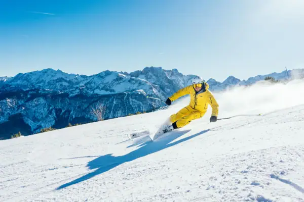 Ski fahren Eine Person fährt auf Skiern einen schneebedeckten Berg hinunter.