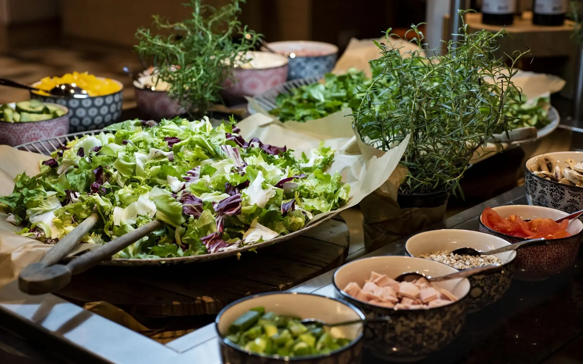 Salat Ein Salatbuffet mit einer großen Salatschüssel und kleinen Beilageschälchen zu beiden Seiten.