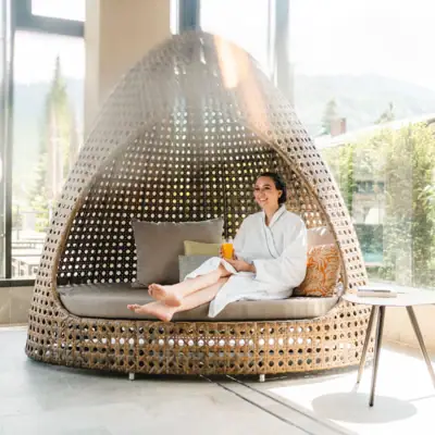 SPA Lounge Eine Frau sitzt auf einem Korbstuhl.