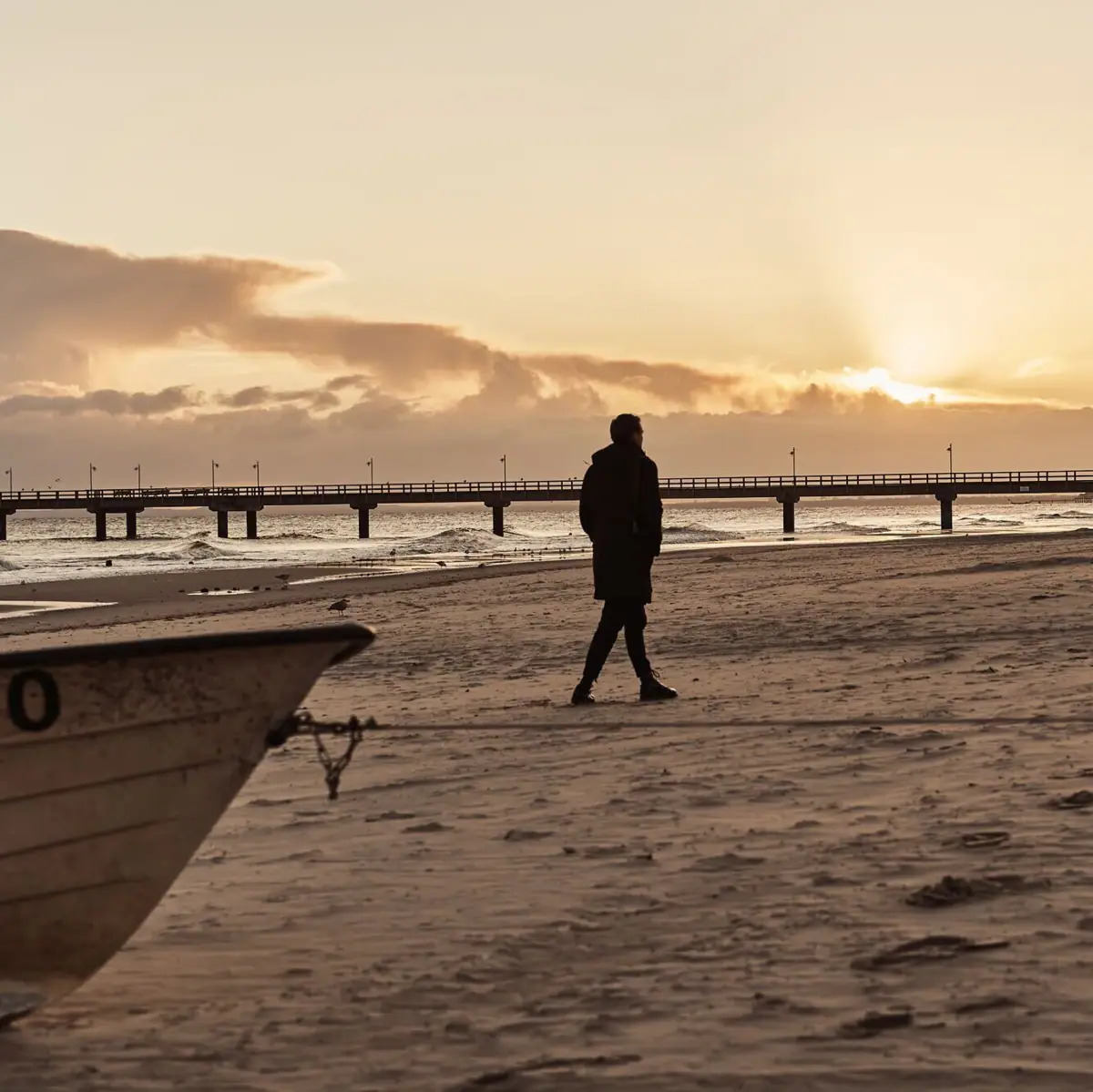 Strandspaziergang Eine Person geht am Strand entlang.