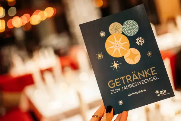 Silvester im aha Ruhpolding Eine Hand hält eine Getränke-Karte für den Silvesterabend