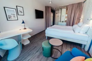 Doppelzimmer Ein Zimmer mit einem Bett, einem Tisch und einem Stuhl.