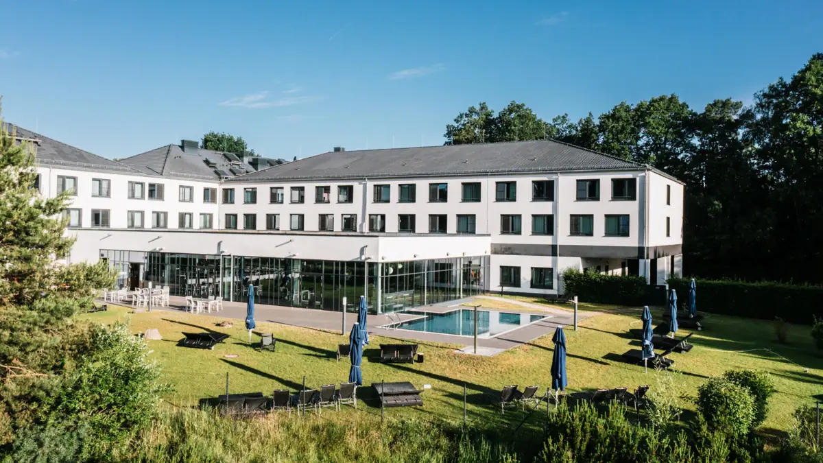 Day SPA in Bad Saarow Ein Gebäude mit einem Pool und Stühlen im Freien.