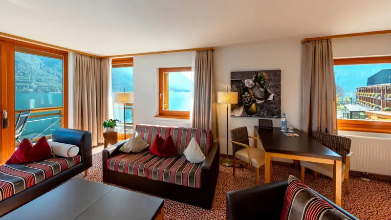 Suite mit Blick auf den See Ein Raum mit Sofas und Stühlen.
