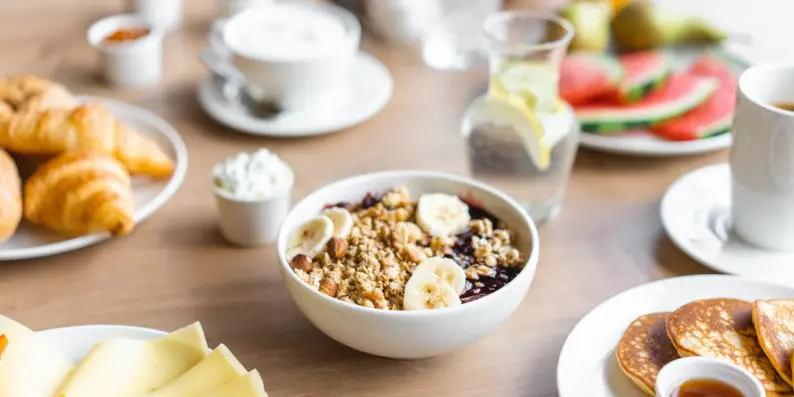 FrühstückstischEin Frühstückstisch mit Müsli, Brötchen, Obst und Getränken. FrühstückstischEin Frühstückstisch mit Müsli, Brötchen, Obst und Getränken.